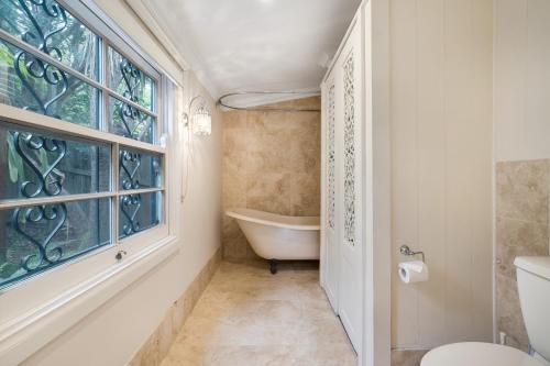 a bathroom with a tub and a toilet and a window at Contemporary Cottage in Perfect Lifestyle Address in Brisbane