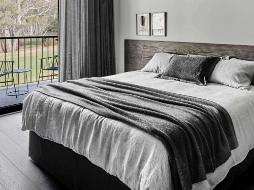 a bedroom with a large bed and a balcony at The Mitchelton Hotel Nagambie in Nagambie