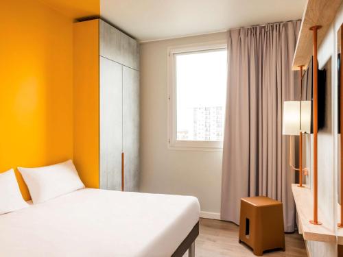 um quarto de hotel com uma cama e uma janela em ibis Budget Mâcon Crêches em Chaintré