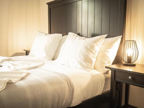 a white bed with white pillows and a lamp on a table at São Lázaro Appartment by Demsimmo in Lisbon