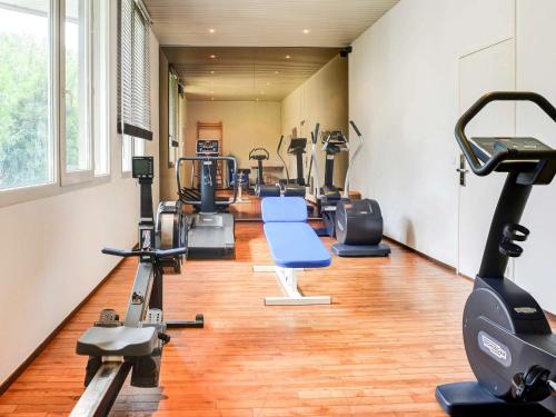 a gym with treadmills and cardio equipment in a room at Novotel Senart Golf De Greenparc in Saint-Pierre-du-Perray