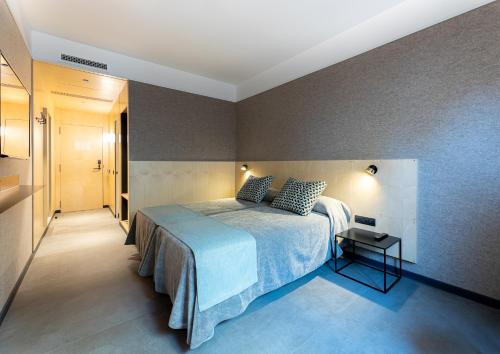 a bedroom with a bed and a small table at Hotel Raval House in Barcelona