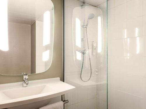 a white bathroom with a sink and a shower at ibis Bordeaux Centre - Gare Saint-Jean in Bordeaux