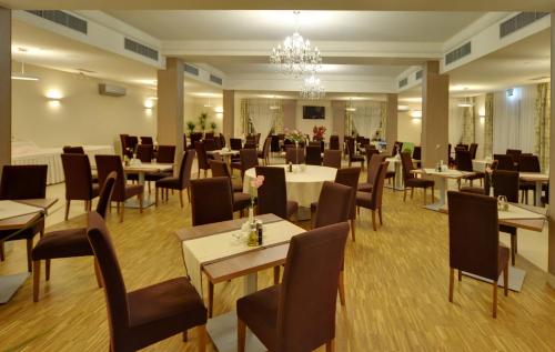 シュツァブノ・ズドルイにあるHotel Camelotのテーブルと椅子、シャンデリアのあるレストラン
