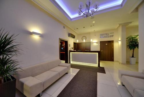 a living room with a couch and a tv at Hotel Camelot in Szczawno-Zdrój