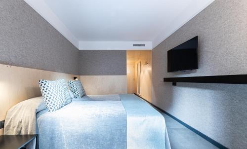 a bedroom with a bed and a television at Hotel Raval House in Barcelona