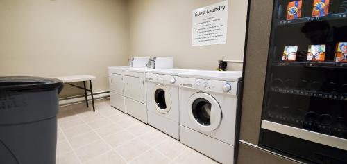 a laundry room with a washing machine and a sink at Wingate by Wyndham Lethbridge in Lethbridge