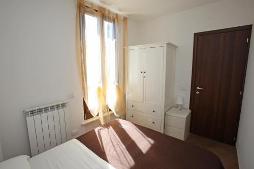 a small bedroom with a bed and a window at Orchidea Rooms & Suites in Civitanova Marche