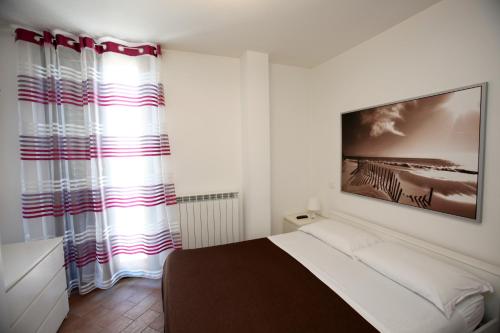 a bedroom with a bed and a large window at Orchidea Rooms & Suites in Civitanova Marche
