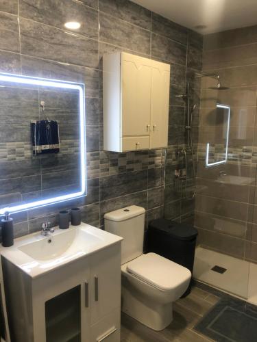 ein Badezimmer mit einem WC, einem Waschbecken und einem Spiegel in der Unterkunft Apartament Burjasot Free Wifi in Burjasot
