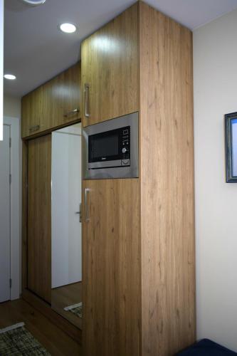 a kitchen with a microwave in a wooden wall at New Gudauri, Red Co, Loft 1 in Gudauri