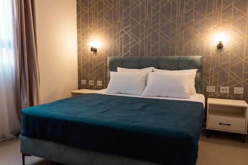 a bedroom with a large bed with a blue blanket at Amwaj Apartments in Nazareth