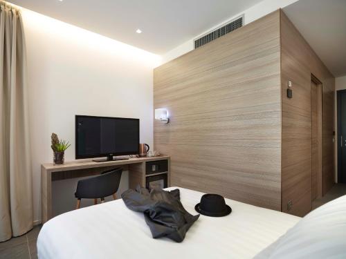 a hotel room with a bed and a flat screen tv at Boutique Hotel Touring in Verona