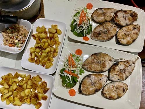 a table with four trays of food on it at Sean Sabai Home e Ristobar in Taling Ngam Beach