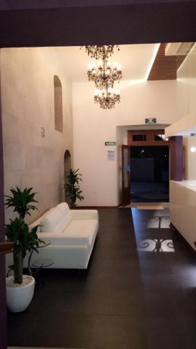 sala de estar con sofá blanco y lámpara de araña en Hotel MS, en Cholula
