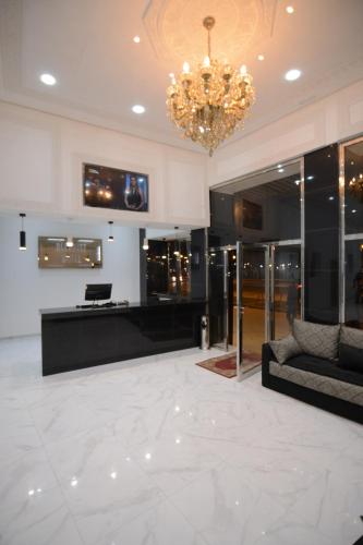 a large lobby with a chandelier and a couch at Hotel Biarritz in Tangier