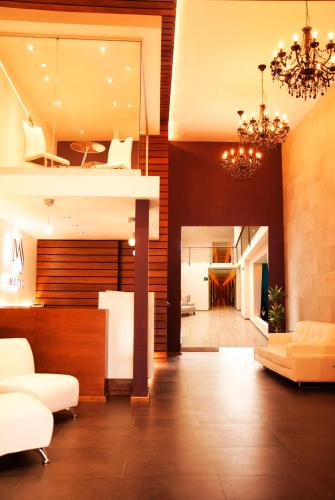 Una sala de estar con muebles blancos y una lámpara de araña. en Hotel MS, en Cholula