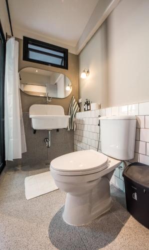 a bathroom with a toilet and a sink at Aridom Designer Loft House in Bangkok