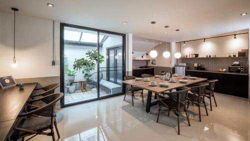 uma sala de jantar e cozinha com mesa e cadeiras em Aridom Designer Loft House em Bangkok