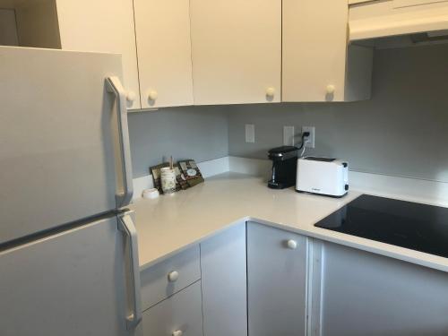 a kitchen with white cabinets and a toaster at Motel 6-Saanichton, BC - Victoria Airport in Saanichton
