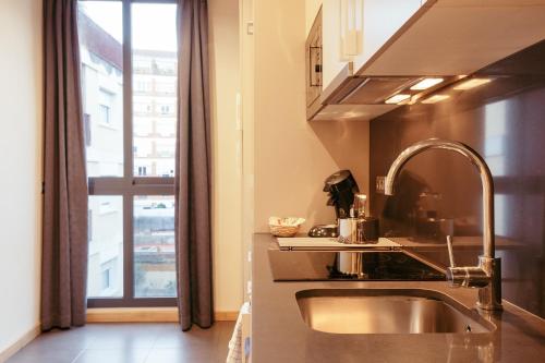cocina con fregadero y ventana grande en Casa Felipa Plaza España, en Barcelona