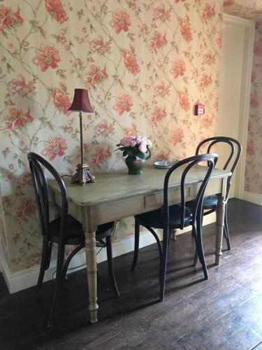 
a dining room table with chairs and a lamp at Basil Sheils B&B Accommodation Armagh in Armagh
