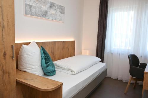 a small bedroom with a bed with a wooden headboard at Gasthof Hotel Adler Inneringen in Inneringen-Hettingen