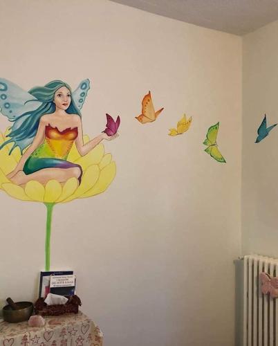 a wall with a mermaid with butterflies on it at Casa Cristallo in Gesso