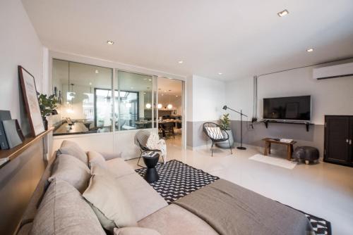 a living room with a couch and a tv at Aridom Designer Loft House in Bangkok