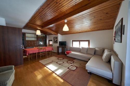 een woonkamer met een bank en een tafel bij Residence Alpen Casavacanze in Pinzolo