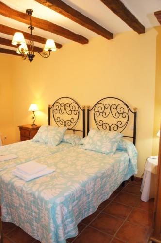 a bedroom with a bed with a blue and white comforter at Casa Rural Blas in Brihuega