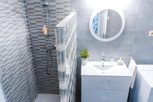 a bathroom with a sink and a shower with a mirror at Apartamento Victoria con parking incluido in Ronda