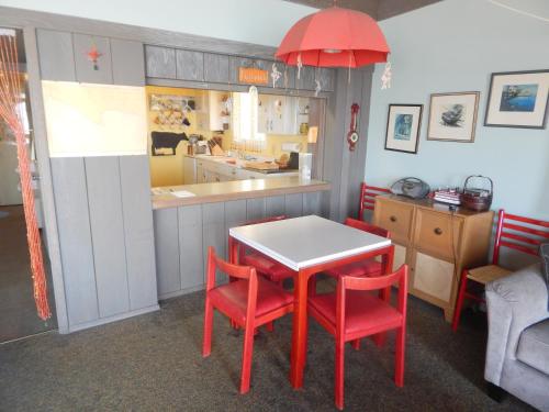 a kitchen with a table and two red chairs at 196 Front Street in Avila Beach