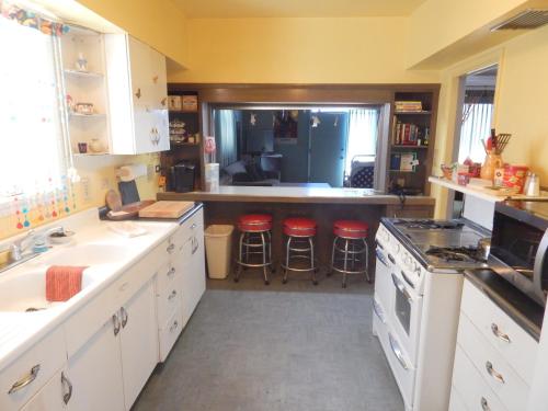 a kitchen with white cabinets and red stools at 196 Front Street in Avila Beach