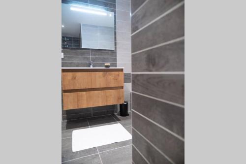 une salle de bain avec un lavabo et un miroir dans l'établissement La grange au pied du Vercors Piscine et SPA privatifs, à Saint-Romans