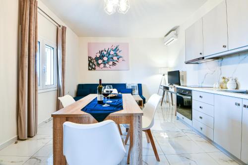 a kitchen and dining room with a table and chairs at Koukounari Luxury Apartments in Vathí