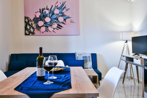 a dining room table with a bottle of wine and glasses at Koukounari Luxury Apartments in Vathí