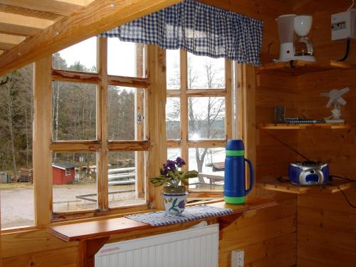 uma cozinha com uma janela num chalé de madeira em Yxningens Holiday Homes, Cottages and Camping em Gusum