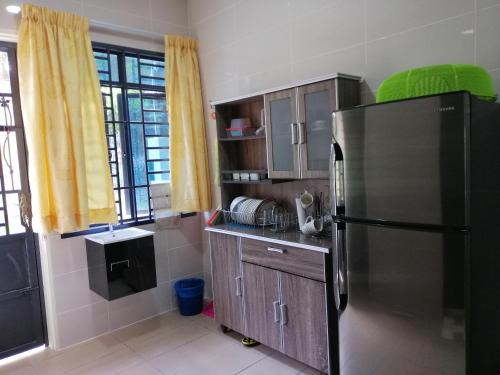una cucina con frigorifero in acciaio inossidabile di A&D Home-stay @Kota Warisan, Sepang (KLIA 15 min) a Sepang
