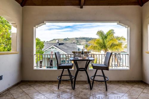 a balcony with a table and chairs and a large window at 28 San Miguel in Avila Beach