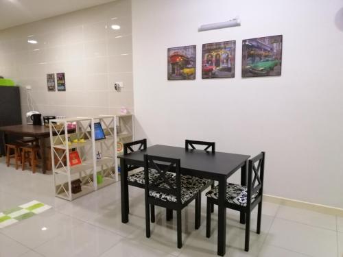 a dining room with a black table and chairs at A&D Home-stay @Kota Warisan, Sepang (KLIA 15 min) in Sepang