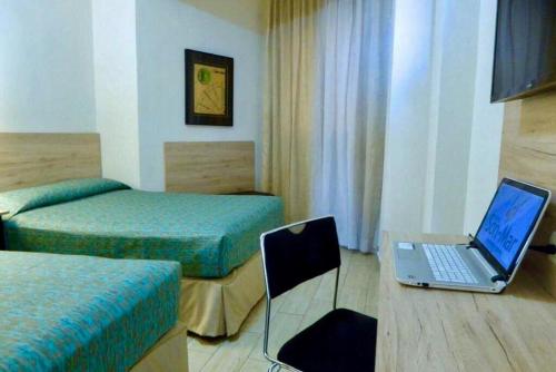 a hotel room with a laptop computer on a desk at Hotel Son- Mar Monterrey Centro in Monterrey