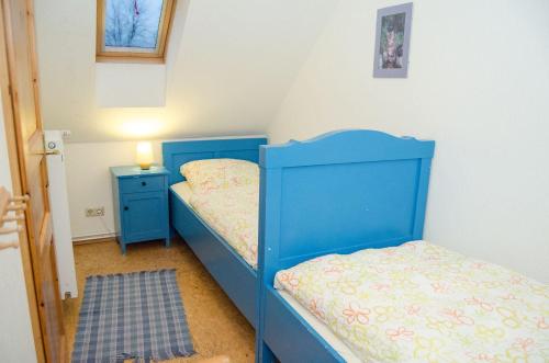 a bedroom with two bunk beds and a blue headboard at Neulandhof Spöring in Walsrode