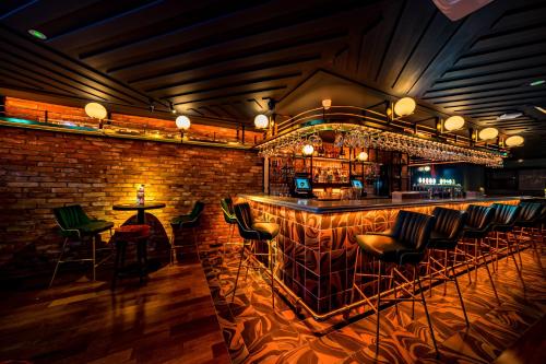 a bar with green chairs and a brick wall at The Old Quarter Townhouse in Limerick