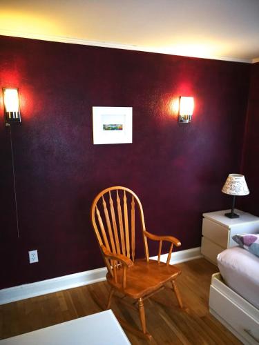 a chair in a living room with a purple wall at Rainbow House and small garden in Princeton