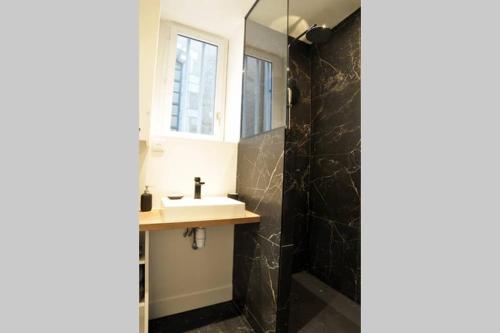 une salle de bain avec un lavabo et un miroir dans l'établissement trendy flat-lyon centre-hotel de ville, à Lyon