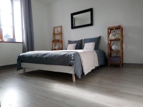 ein Schlafzimmer mit einem Bett in einem weißen Zimmer in der Unterkunft GITE LE SAINT-AMOUR in Saint-Amour