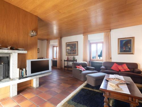 ein Wohnzimmer mit einem Sofa und einem TV in der Unterkunft Belvilla by OYO Casa Vacanze a Stenico in Steinig