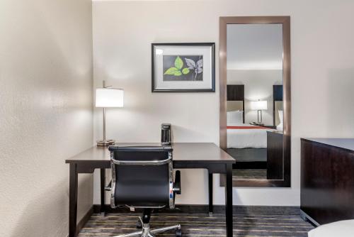 a hotel room with a desk and a bed at Comfort Inn & Suites Tigard near Washington Square in Tigard