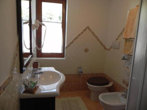 a bathroom with a sink and a toilet and a window at B&B Il Grappolo in Anacapri